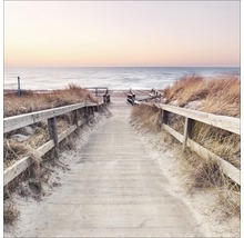 Houten loopbrug met reling leidt naar het strand