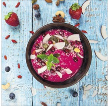 Bovenaanzicht van een smoothiebowl met aardbeien, blauwe bessen, kokosnoot, noten en munt