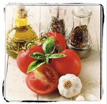 Stilleven met tomaten, basilicum, knoflook, olie en kruidenmolens op een tafel