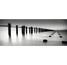 Zwart-witfoto van een houten steiger die de zee inloopt