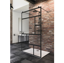 Inloopdouche met zwart frame en douchekop in een badkamer met wastafel en bakstenen muur.