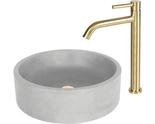 Ronde opzetwastafel van beton met gouden kraan