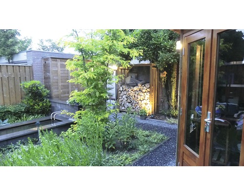 Tuinscene met vijver, houtopslag en tuinhuis