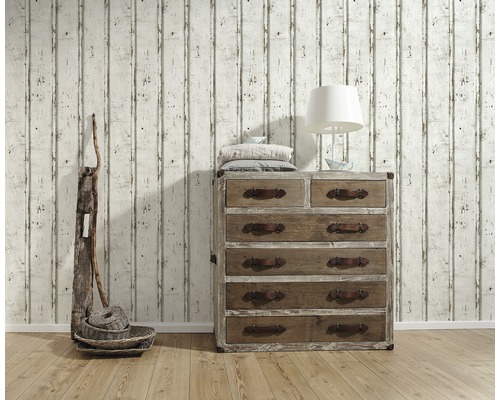 Woonkamer scène met houten ladekast, lamp, decoratie en behang met houtlook