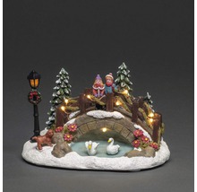 Decoratief winterlandschap met brug, figuren, bomen en verlichting voor een feestelijke sfeer.