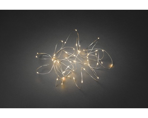 KONSTSMIDE Kerstverlichting LED druppellichtsnoer 50 lampjes extra warmwit 4,9 m LED-lichtslinger op een donkere achtergrond