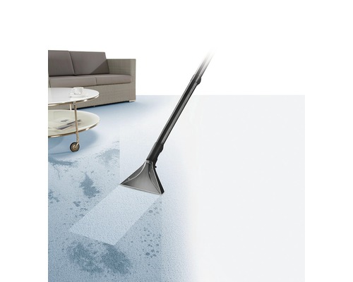 Tapijtreiniger in gebruik voor het verwijderen van vlekken op een tapijt