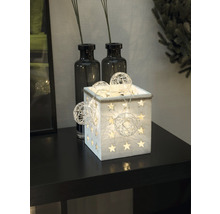 Decoratieve houten kist met sterren en lichtslingers op een tafel.