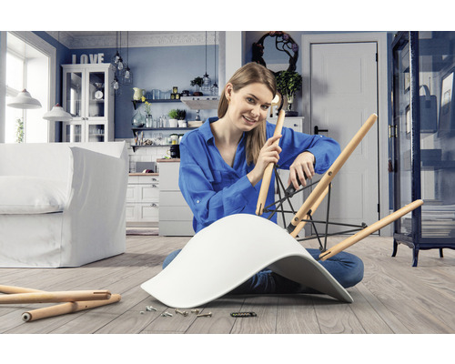 Vrouw monteert stoel in lichte woonkamer