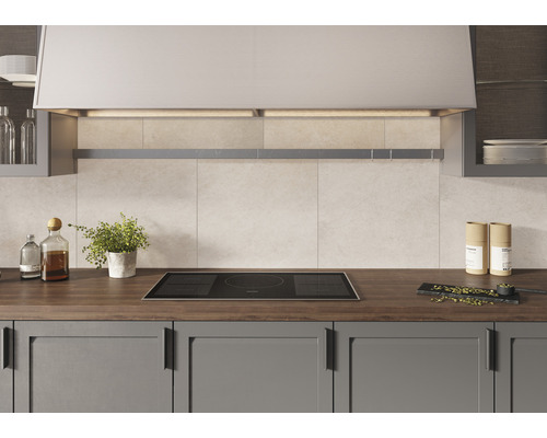 Keukenscène met inductiekookplaat, afzuigkap en keukengerei op een aanrechtblad