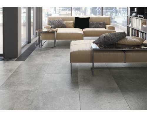 Moderne woonkamer met tegelvloer, bank en boekenkast