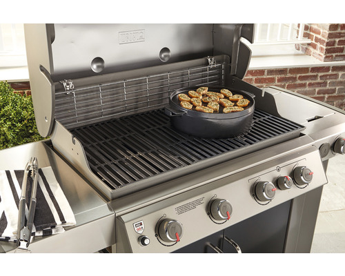 Roestvrijstalen barbecue met voedsel op grillplaat en grilltang