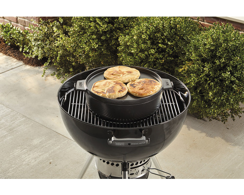 Bolvormige barbecue met grillplaat en platbrood in de tuin