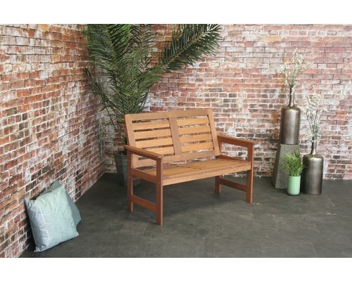 Houten bank voor buiten voor een bakstenen muur met planten