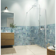 Badkamer met douche, wastafelonderkast, spiegel en blauwe bakstenen wandtegels.