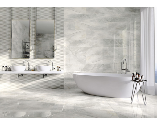 Moderne badkamer met ligbad, dubbele wastafel en tegels met marmerlook.