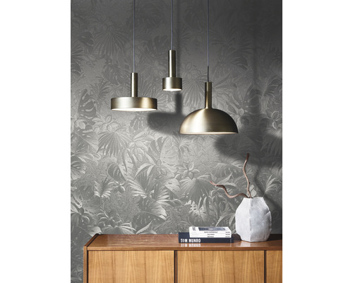 Scene met drie hanglampen boven een houten kast tegen een behang met motief