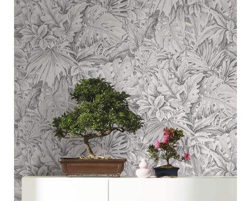 Decoratief behang met een botanisch bladerdesign als achtergrond voor twee bonsai boompjes op een plank
