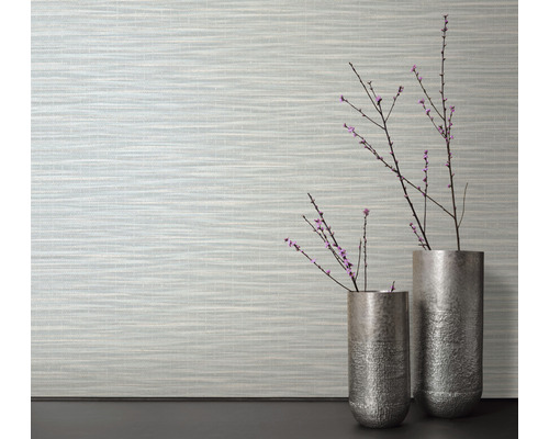 Woonkamer met patroonbehang en twee zilverkleurige vazen met takken
