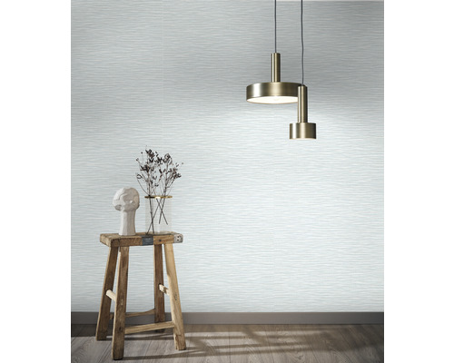 Woonkamer met behang in golfmotief, hanglampen, kruk en decoratie