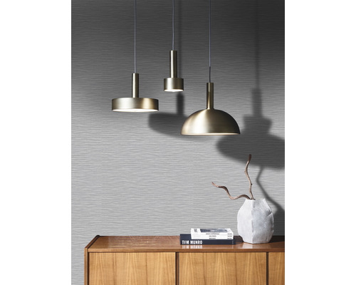 Drie metalen hanglampen boven een houten kast