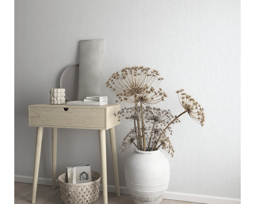 Decoratieve scène met een houten bijzettafel, een vaas met gedroogde bloemen en decoratieve accessoires.