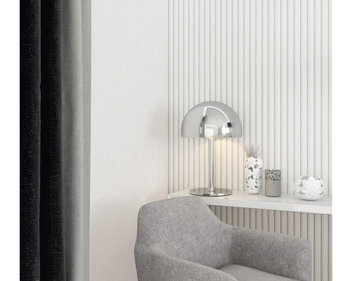 Decoratieve woonkamer met grijze fauteuil, zilveren lamp en bloemaccenten