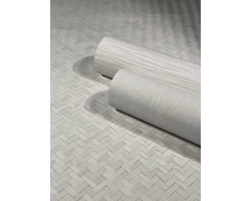 Twee rollen textiele vloerbedekking op een gevlochten ondergrond