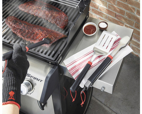 Afbeelding van een barbecue, vlees, barbecuegereedschap, marinade en barbecuehandschoen.