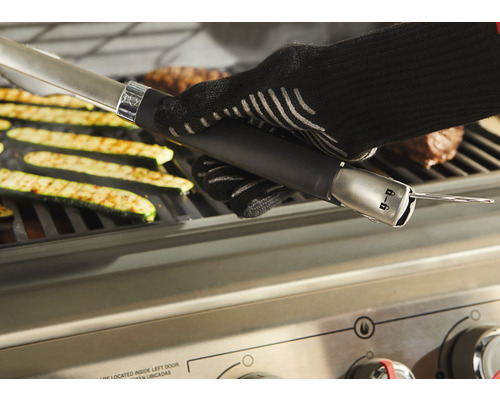 Grilltang met barbecuehandschoen bij het grillen van groenten en vlees op een barbecue