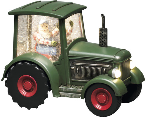 Decoratieve groene tractor met kerstmanfiguur en sneeuw