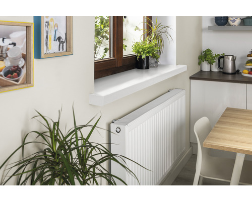 Radiator onder een vensterbank in een kamer.