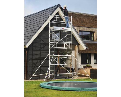 Aluminium rolsteiger voor een huis met een persoon op het platform