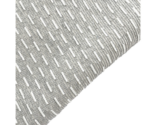 Detailopname van een grijs tapijt met witte sierstiksels