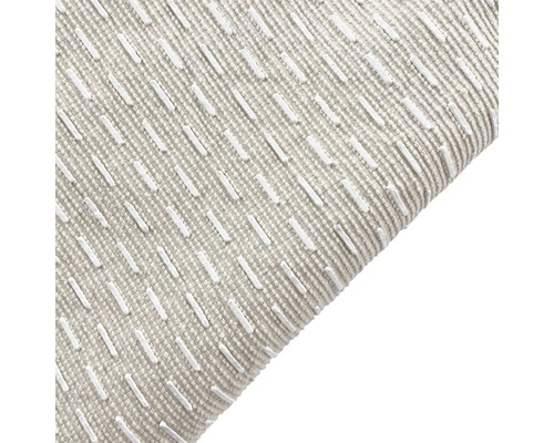 Close-up van een kussen met textuur en geborduurd patroon