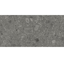 Close-up van een grijze vloertegel met terrazzo patroon