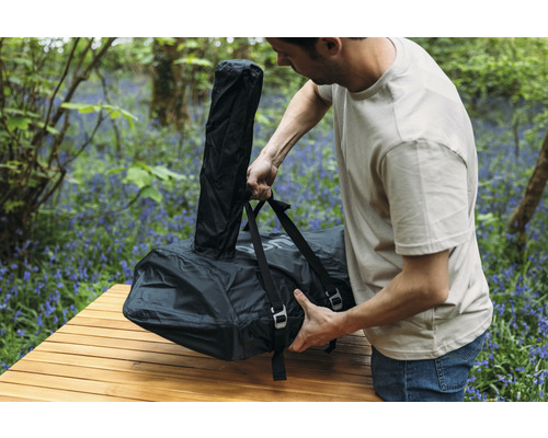 Man pakt ingepakt campingbedje op een tafel