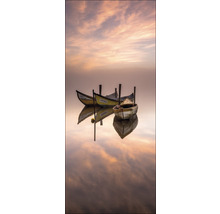 Drie kleine boten liggen stil op het water en spiegelen zich in het water.
