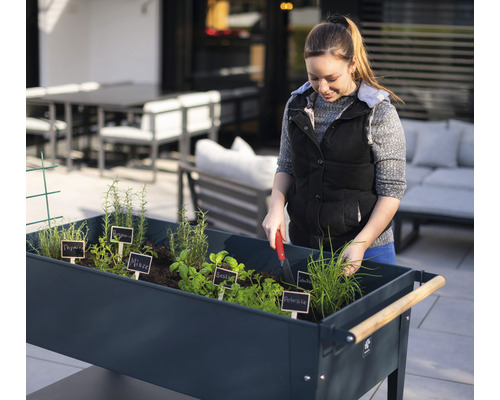 Vrouw werkt in tuinbed met kruiden buiten