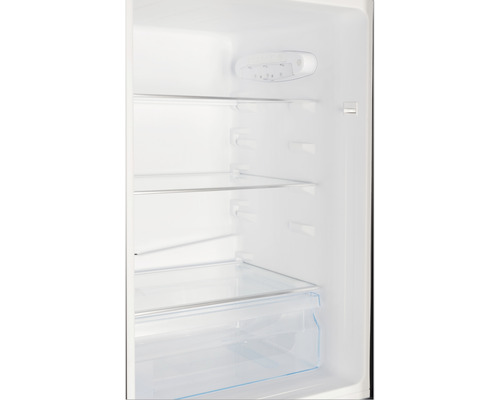 Interieur van een koelkast met glazen planken en groentelade