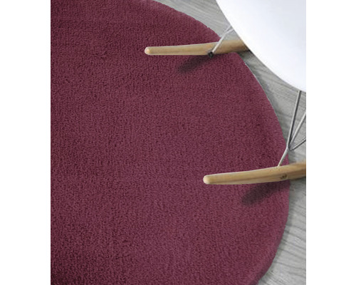 Gedetailleerd zicht op een rond, getextureerd vloerkleed onder een stoel