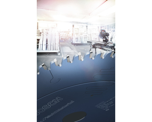 Cirkelzaagblad op de voorgrond, verstekzaag en werkplaats op de achtergrond