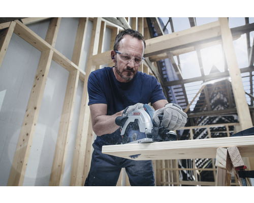 Man zaagt hout met een Bosch invalzaag in een lichte werkplaats