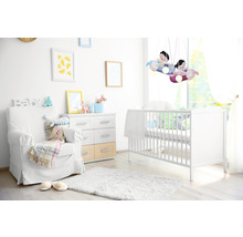 Lichte kinderkamer met kinderbed, fauteuil en decoratieve vliegtuiglamp