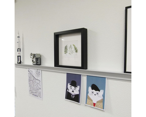 Wanddecoratie met fotolijsten, plank en posters