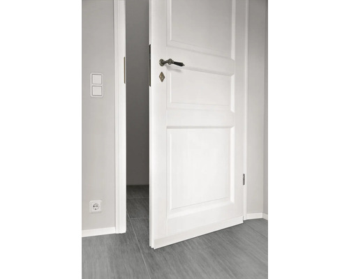 Openstaande witte binnendeur met deurklink