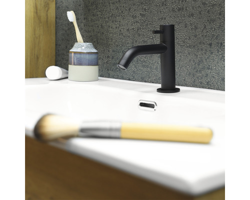 Badkamer wastafel met kraan, tandenborstel, beker en make-up borstel