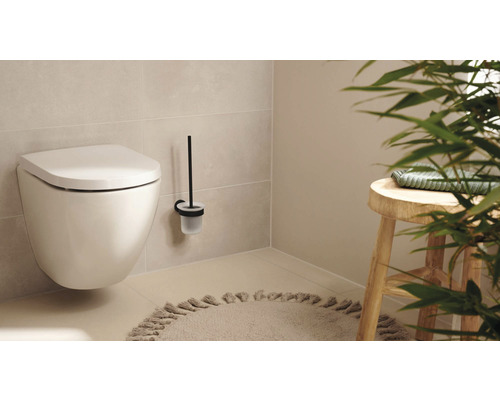 Wandcloset met toiletborstel en kruk in een lichte badkamer