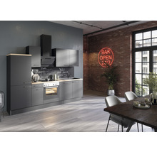 Moderne keuken met grijze kasten, afzuigkap, eettafel en stoelen in een ruimte met een bakstenen muur.