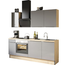 Moderne keuken met grijze kasten, spoelbak, fornuis en afzuigkap.